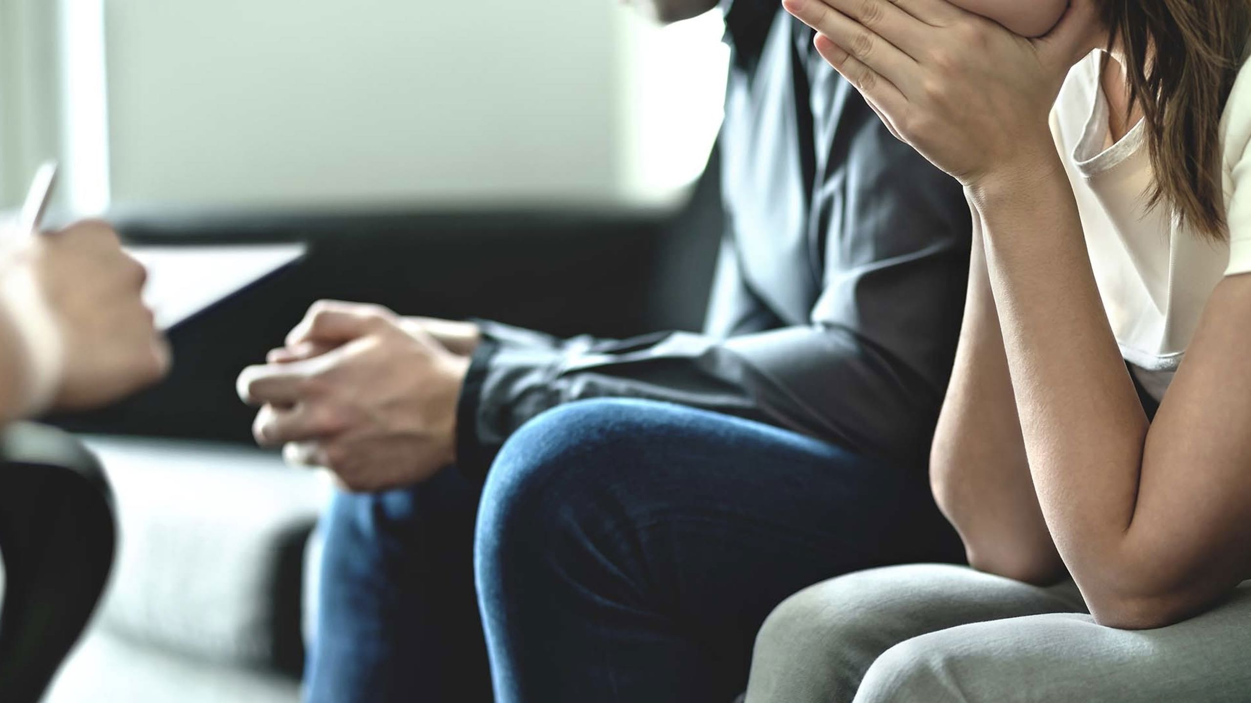 To mennesker sitter i en sofa. Man ser kun hender og ikke ansikt.