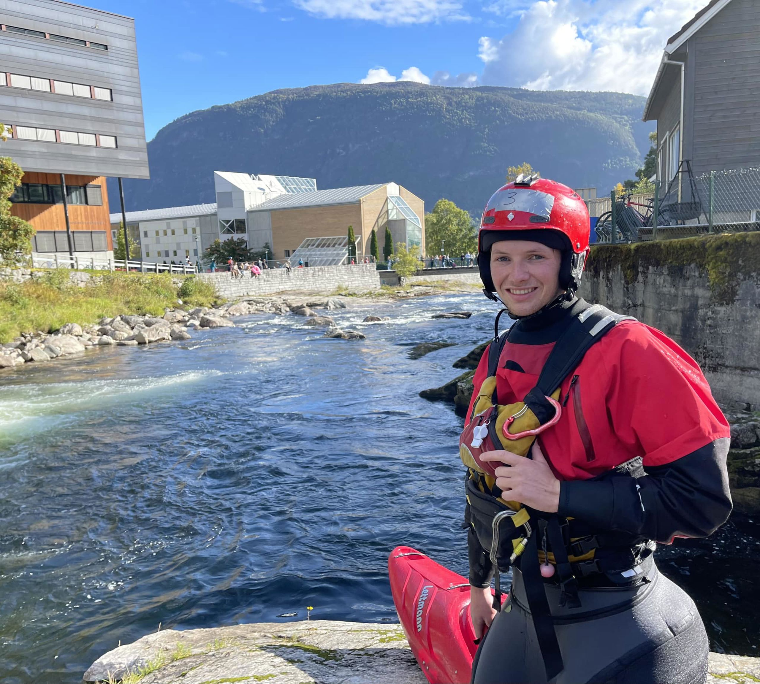 HVL-student Ruben Johnsen Davidsen i padleutstyr, framføre Sogndalselvi og campus Sogndal. 