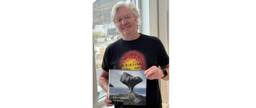 HVL-tilsett Thorbjørn Kaland poserer med boka «Landskapet forteller. 100 historier fra Norges geologi»