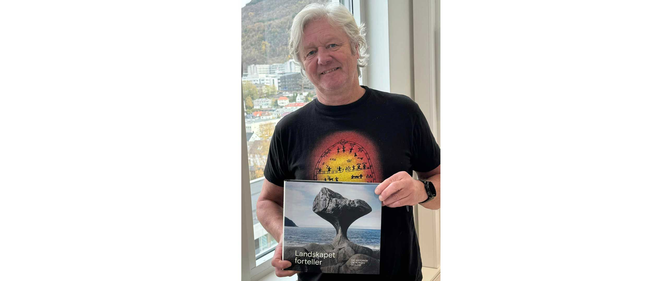 HVL-tilsett Thorbjørn Kaland poserer med boka «Landskapet forteller. 100 historier fra Norges geologi»