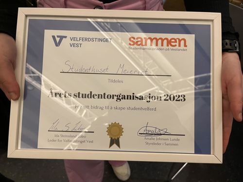 Innramma diplom med teksten "Studenthuset Meieriet tildeles Årets studentorganisasjon 2023 for sitt bidrag til å skape studentvelferd. 