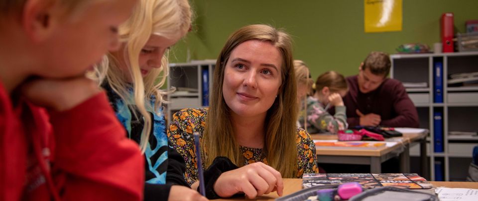Student sammen med elev i klasserommet.